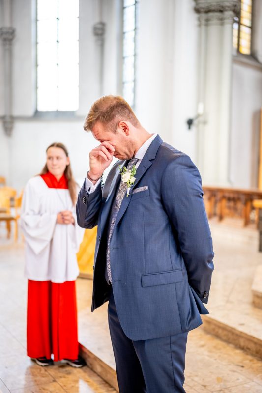 Ein Bräutigam in der St. Anna Kirche in Krefeld wischt sich die Tränen aus den Augen, nachdem er seine Braut die Kirche betreten sah.